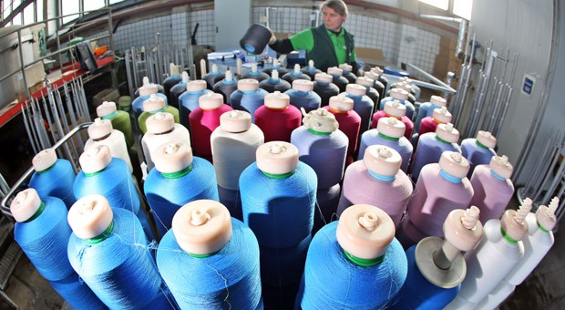 Ein Mitarbeiter der Firma Alterfil Nähfaden sortiert Garnspulen nach der Färberei und Veredlung in Oederan (Sachsen). Seit 20 Jahren produziert die Firma mit derzeit 45 Mitarbeitern unterschiedlichste Garne und Nähfäden in Sachsen.