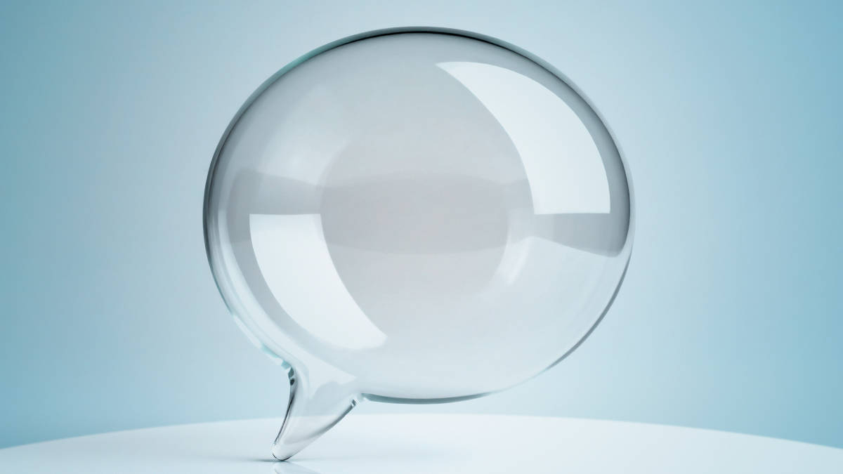 Gläserne Sprechblase vor hellblauem Hintergrund