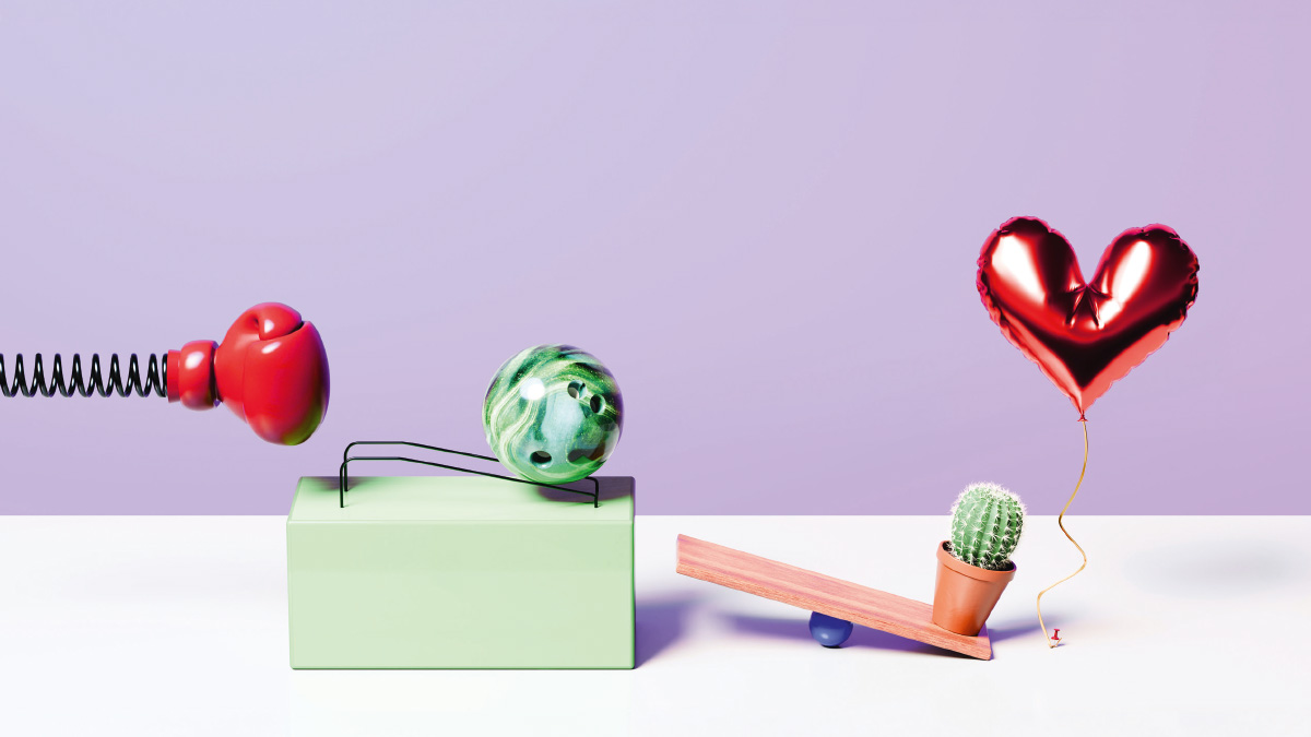 Absurdes Modell einer Kettenreaktion aus Boxhandschuh, Bowlingkugel und Luftballon