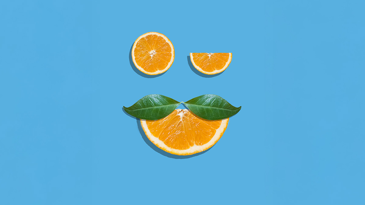 Smiley aus Orangen-Stücken und einem Blätter-Schnauzer