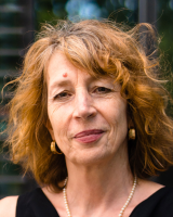 Mittelalte Frau mit rotbraunen Haaren blickt in die Kamera