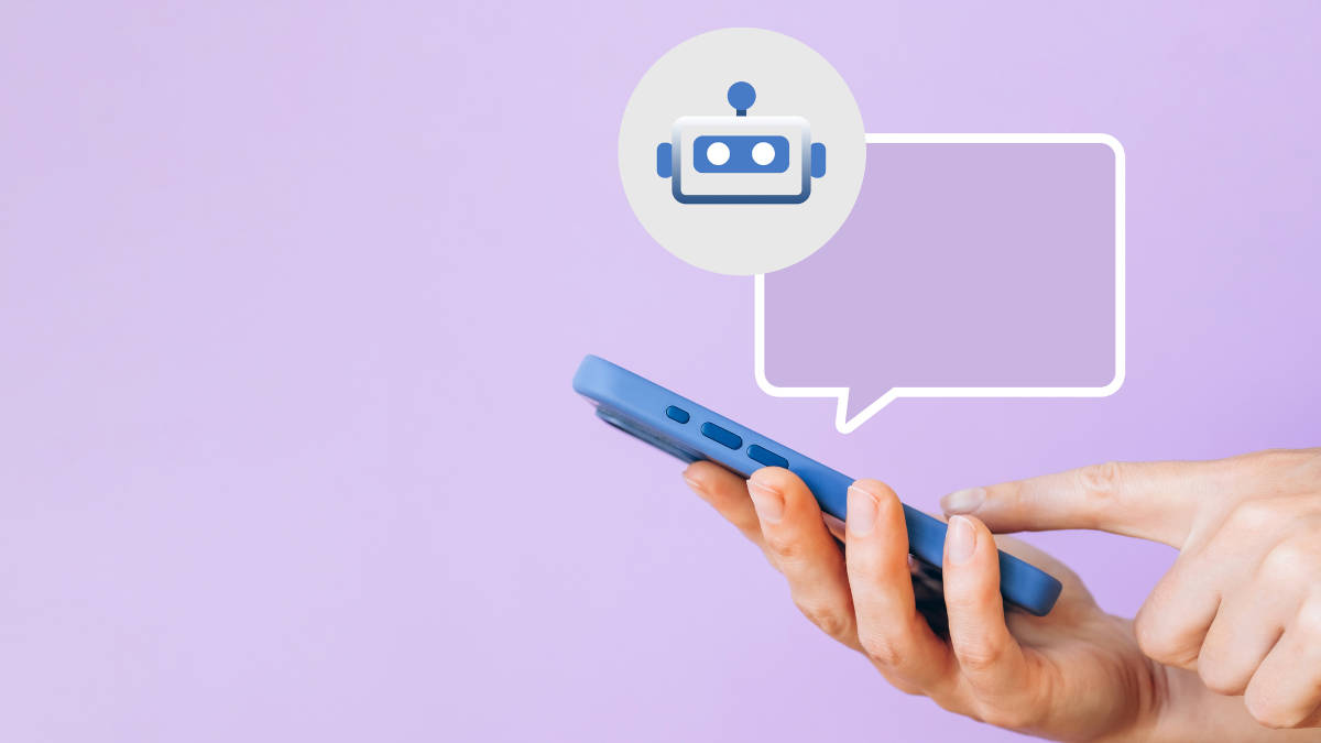 Eine Person hält ein Handy mit einer Sprechblase darüber mit dem Bild eines Roboters darin.
